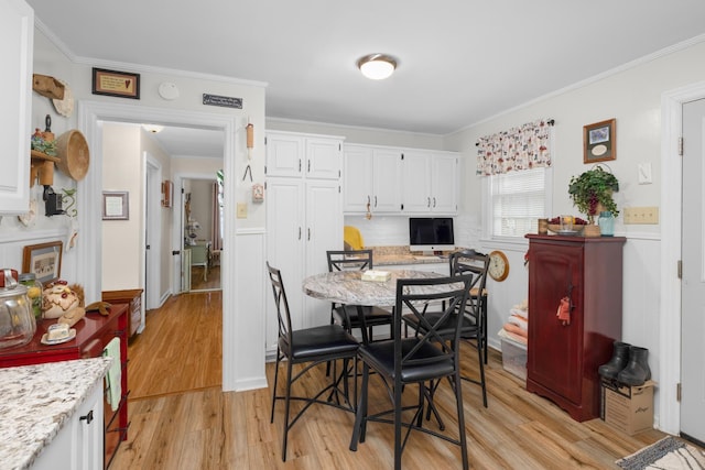 dining room featuring ornamental molding and light hardwood / wood-style flooring