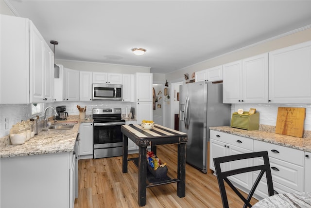 kitchen with tasteful backsplash, appliances with stainless steel finishes, sink, and white cabinets