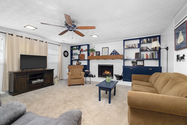 living room with a fireplace, light colored carpet, and ceiling fan