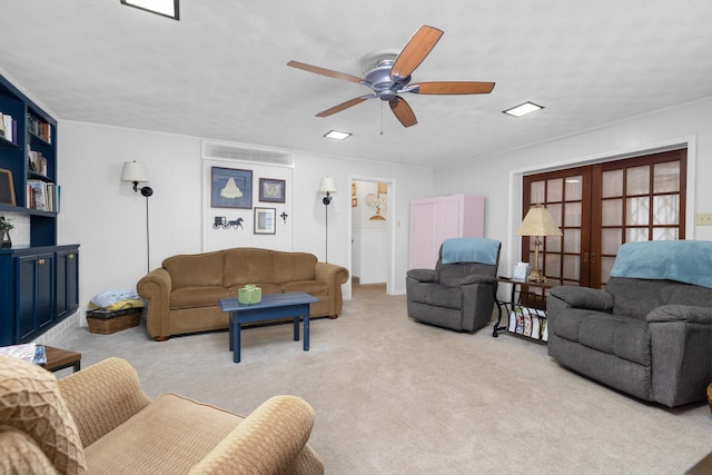 living room with french doors, light colored carpet, ornamental molding, and ceiling fan