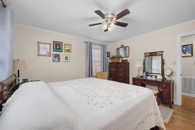 bedroom with ornamental molding, ceiling fan, and light wood-type flooring