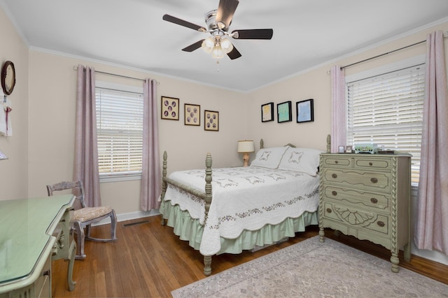 bedroom with hardwood / wood-style flooring, ornamental molding, and ceiling fan