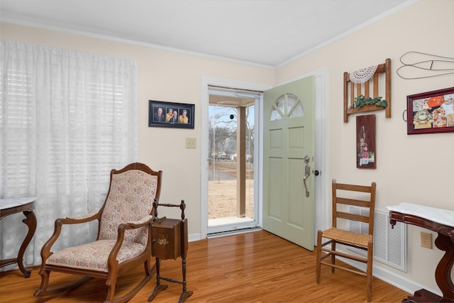 sitting room featuring crown molding and light hardwood / wood-style flooring