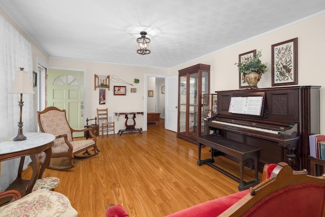 living area featuring crown molding and light wood-type flooring