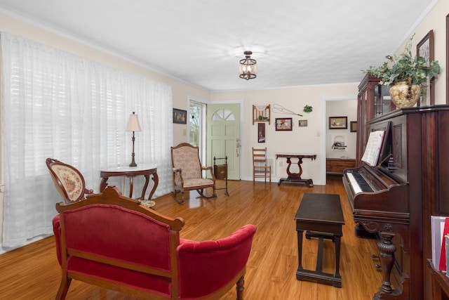 living area with wood-type flooring and crown molding