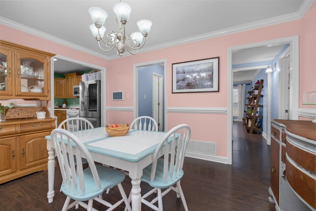 dining space featuring crown molding, dark wood-type flooring, and a chandelier