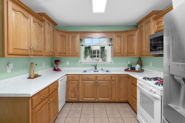 kitchen with appliances with stainless steel finishes, sink, and light tile patterned floors