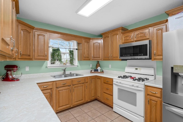 kitchen with sink, light tile patterned floors, and stainless steel appliances