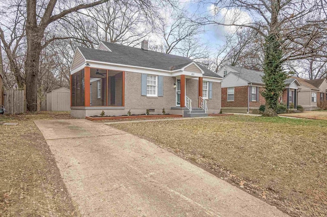 bungalow-style house featuring a storage shed and a front yard