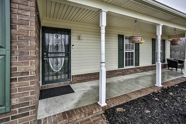 view of exterior entry featuring covered porch