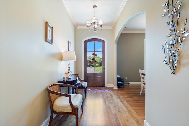 entryway featuring hardwood / wood-style flooring, crown molding, and an inviting chandelier