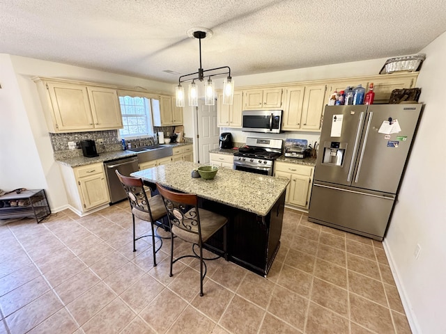 kitchen featuring sink, a kitchen breakfast bar, a kitchen island, pendant lighting, and stainless steel appliances