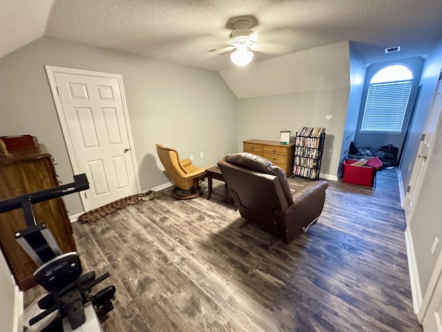 sitting room with vaulted ceiling, dark hardwood / wood-style floors, ceiling fan, and a textured ceiling