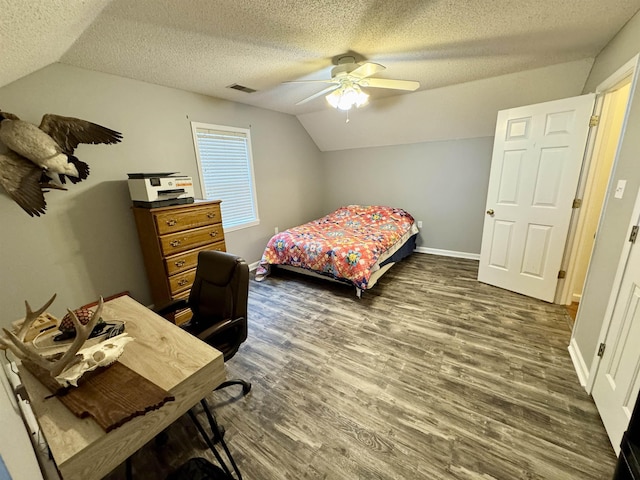 bedroom with dark hardwood / wood-style flooring, ceiling fan, vaulted ceiling, and a textured ceiling