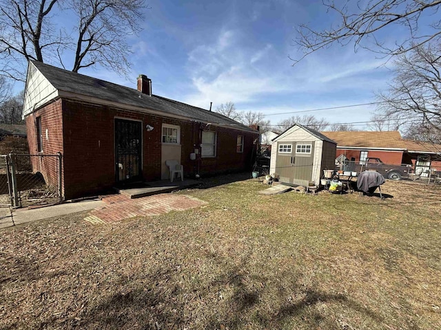 rear view of property featuring a yard and a shed