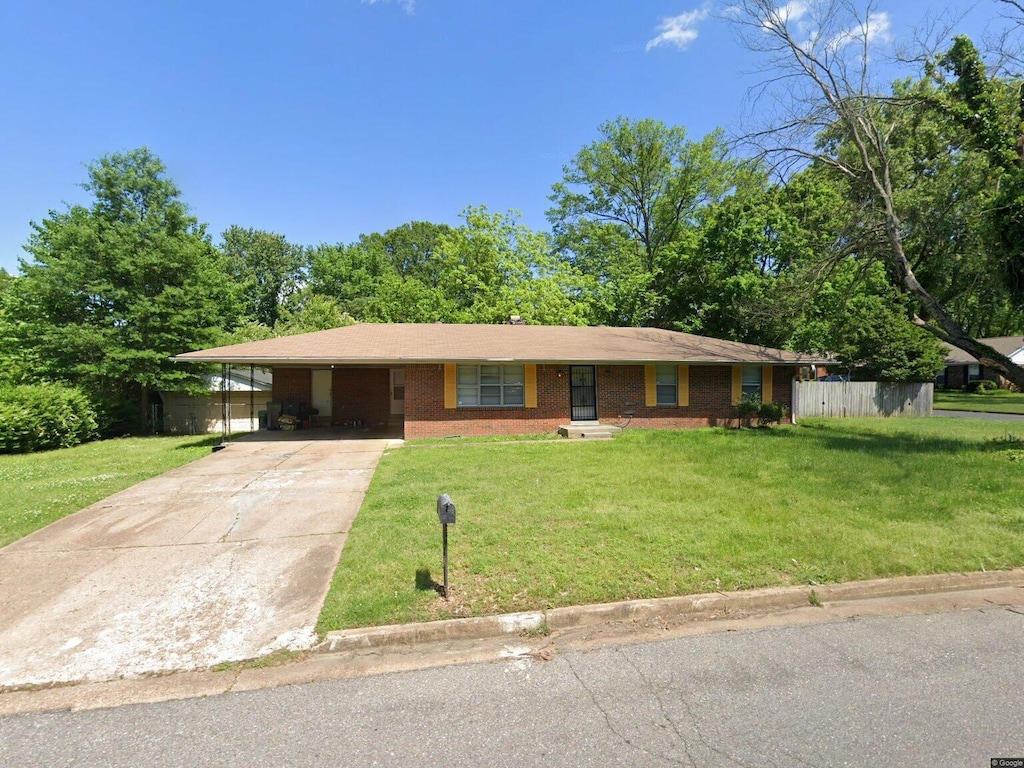 ranch-style home featuring a front lawn and a carport