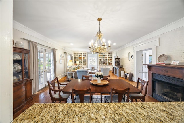 dining area featuring an inviting chandelier, ornamental molding, dark hardwood / wood-style floors, and french doors