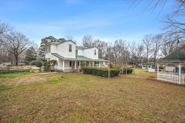 view of home's exterior featuring a gazebo, a lawn, and covered porch