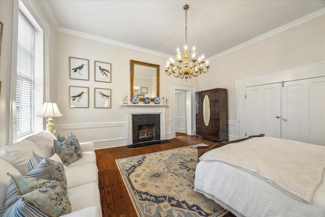 bedroom featuring an inviting chandelier, dark wood-type flooring, ornamental molding, and a closet