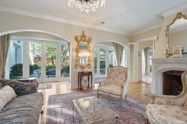 living room with light hardwood / wood-style flooring, crown molding, plenty of natural light, and french doors