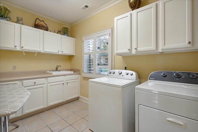 washroom featuring sink, crown molding, washer and clothes dryer, light tile patterned floors, and cabinets