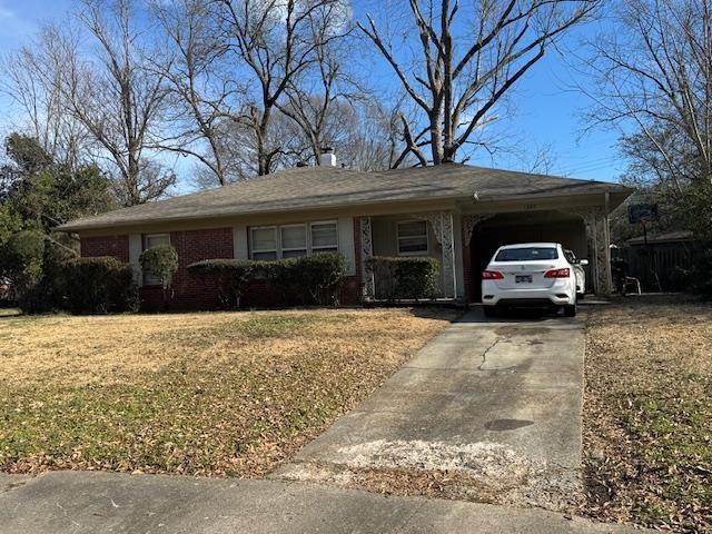 ranch-style home with a garage, a front lawn, and a carport