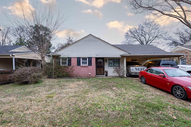 ranch-style home with a carport and a yard