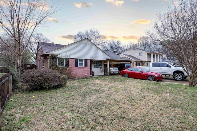 view of front facade with a carport and a lawn