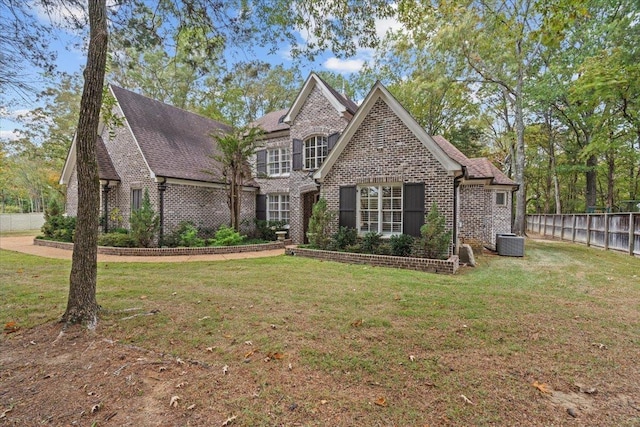 view of front of property with central air condition unit and a front lawn