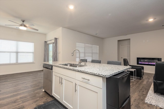 kitchen featuring dishwasher, an island with sink, sink, white cabinets, and dark hardwood / wood-style flooring