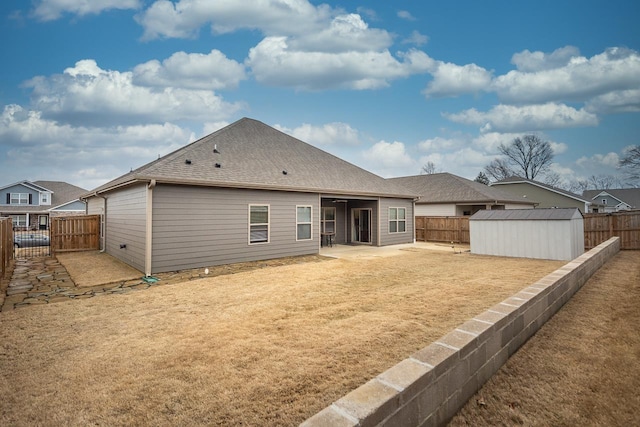 back of property with a storage shed and a patio