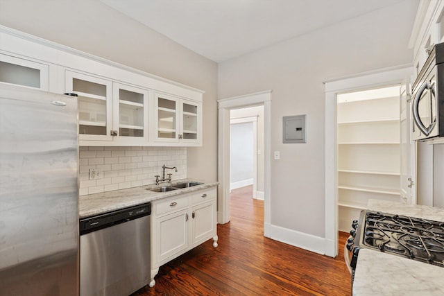 kitchen with sink, appliances with stainless steel finishes, white cabinetry, light stone counters, and tasteful backsplash