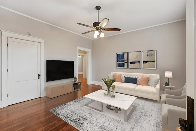 living room featuring dark hardwood / wood-style flooring, ornamental molding, and ceiling fan