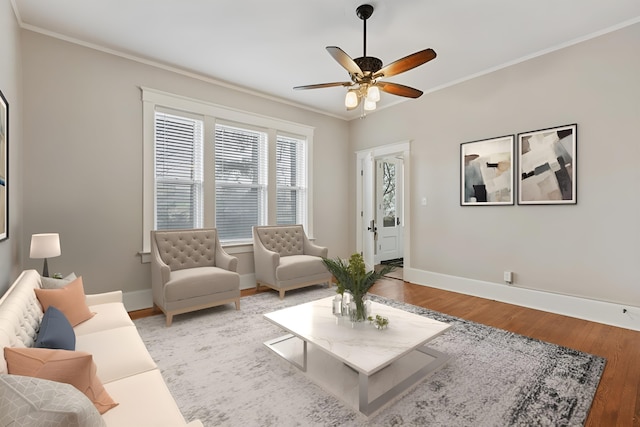 living room featuring light hardwood / wood-style flooring, ornamental molding, and ceiling fan