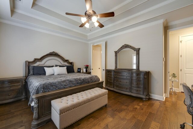 bedroom featuring ceiling fan, a tray ceiling, dark hardwood / wood-style floors, and ornamental molding