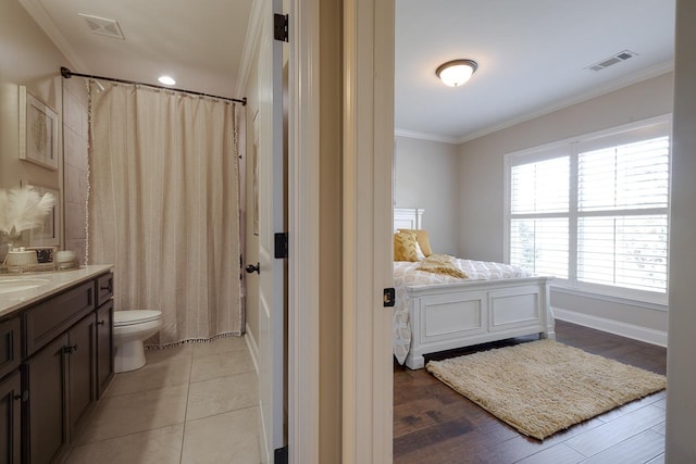 bathroom featuring vanity, tile patterned floors, ornamental molding, and toilet