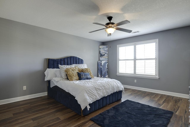 bedroom with ceiling fan, a textured ceiling, and dark hardwood / wood-style flooring