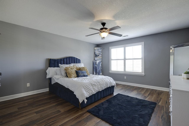 bedroom featuring ceiling fan, dark hardwood / wood-style floors, and a textured ceiling