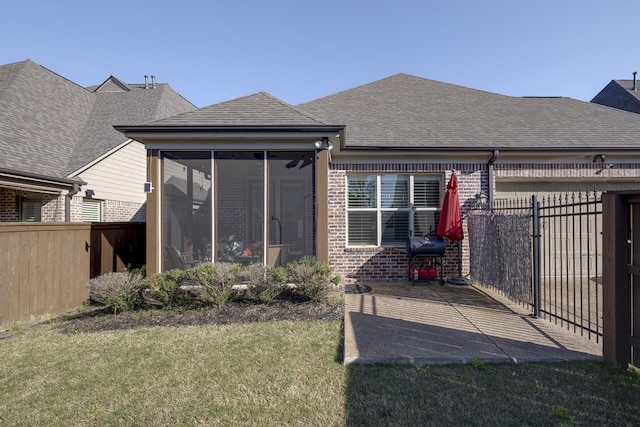 rear view of house featuring a sunroom and a lawn