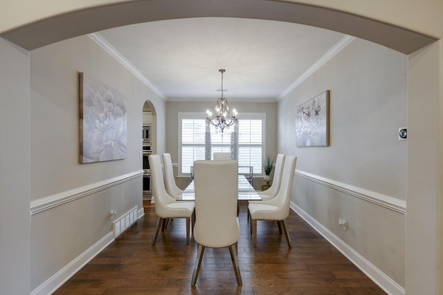 dining space with crown molding, dark hardwood / wood-style floors, and a chandelier