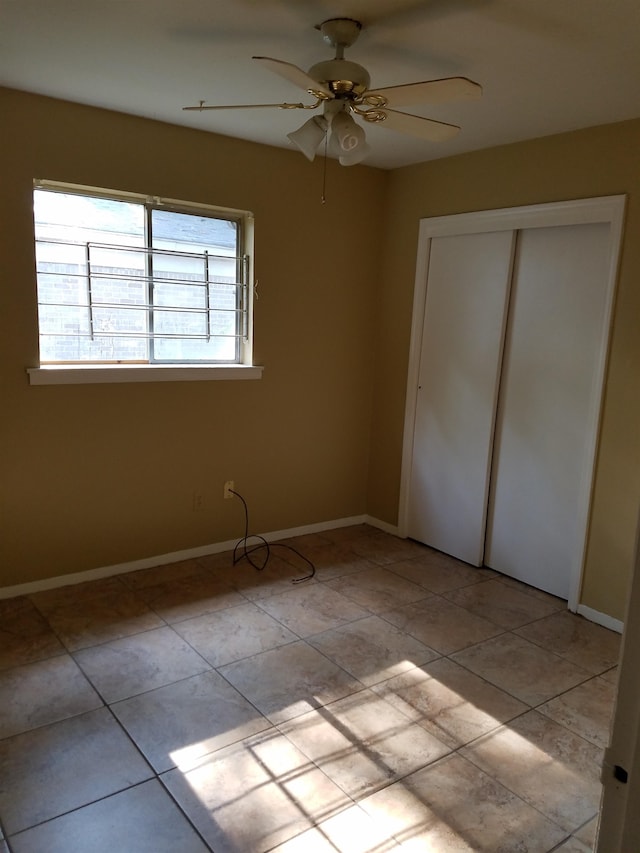 unfurnished bedroom with light tile patterned floors, a closet, and ceiling fan