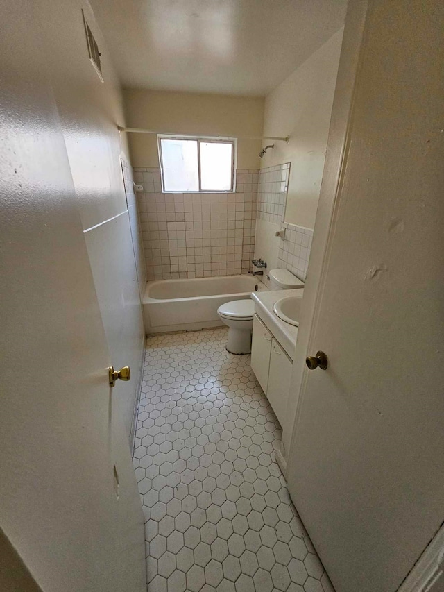 full bathroom featuring tile patterned floors, vanity, toilet, and tiled shower / bath combo