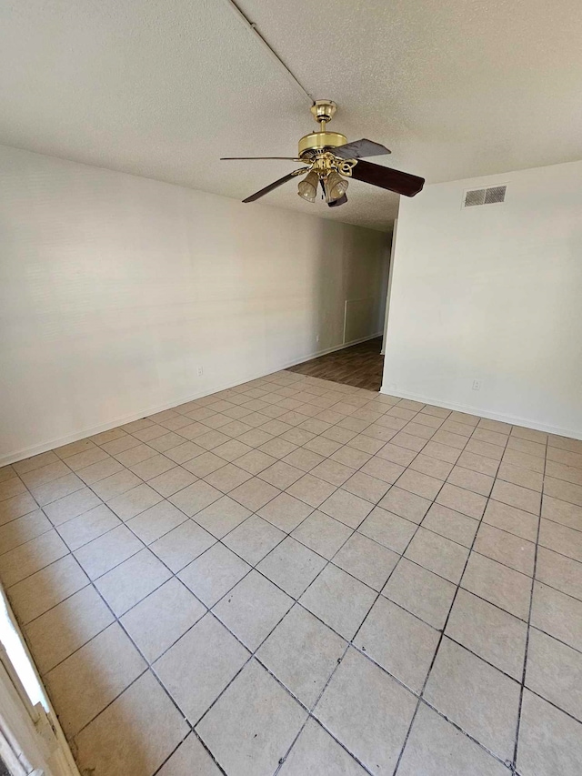 spare room with a textured ceiling and ceiling fan