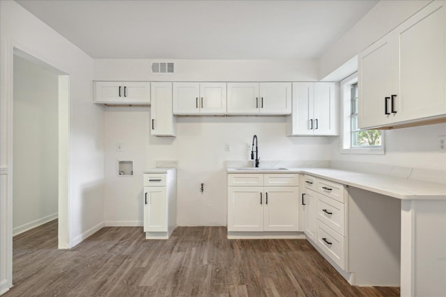 kitchen featuring dark hardwood / wood-style flooring, sink, and white cabinets