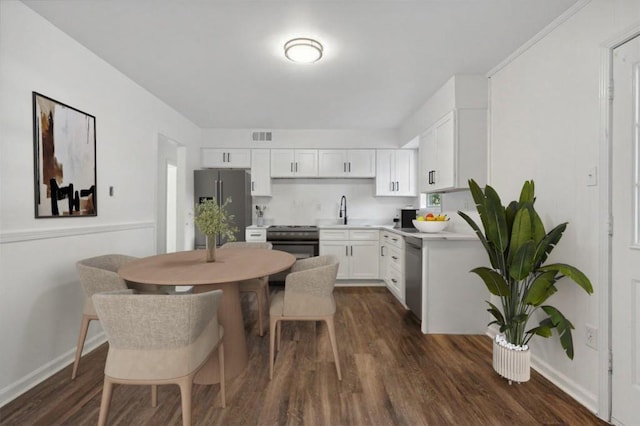 kitchen with white cabinetry, appliances with stainless steel finishes, sink, and dark hardwood / wood-style flooring