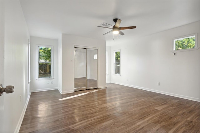 empty room with dark wood-type flooring, ceiling fan, and plenty of natural light