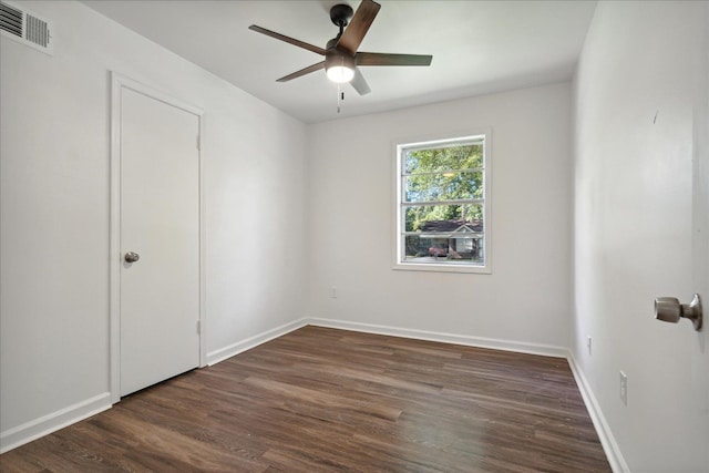 spare room with dark wood-type flooring and ceiling fan