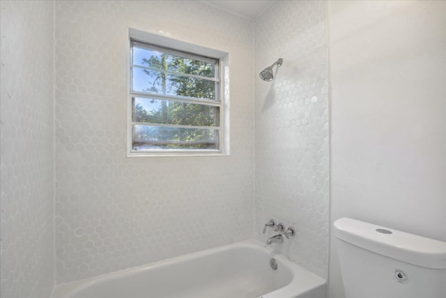 bathroom featuring tiled shower / bath and toilet