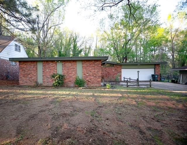 view of front of property with aphalt driveway, brick siding, and an attached garage