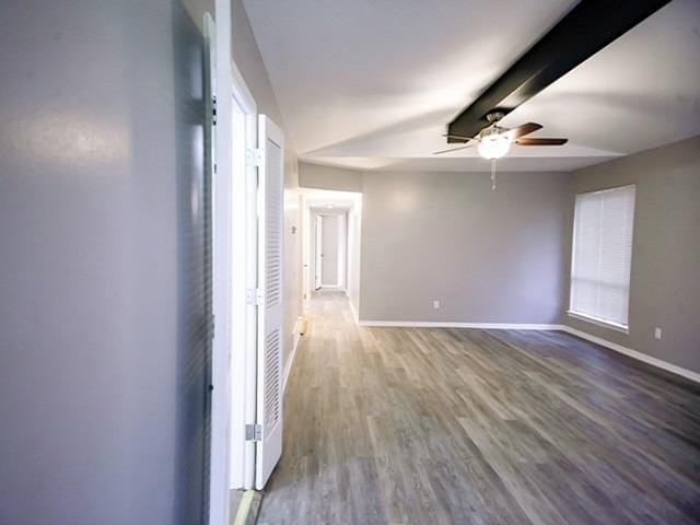 spare room featuring hardwood / wood-style flooring, ceiling fan, and beam ceiling